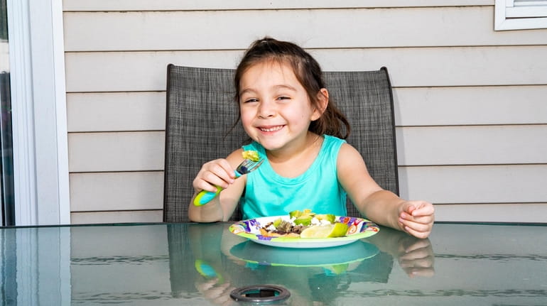Naomi Romero, 4, digs into a plate of sopes, a...