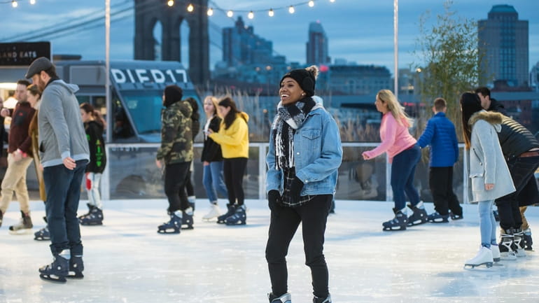 Skaters try out the riverside ice-skating rink at Seaport Square,...