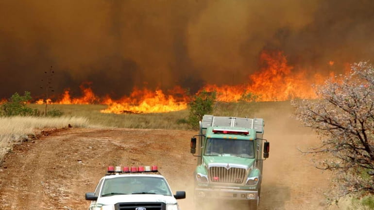 Fire trucks escape the flames near South Andalusian Way after...