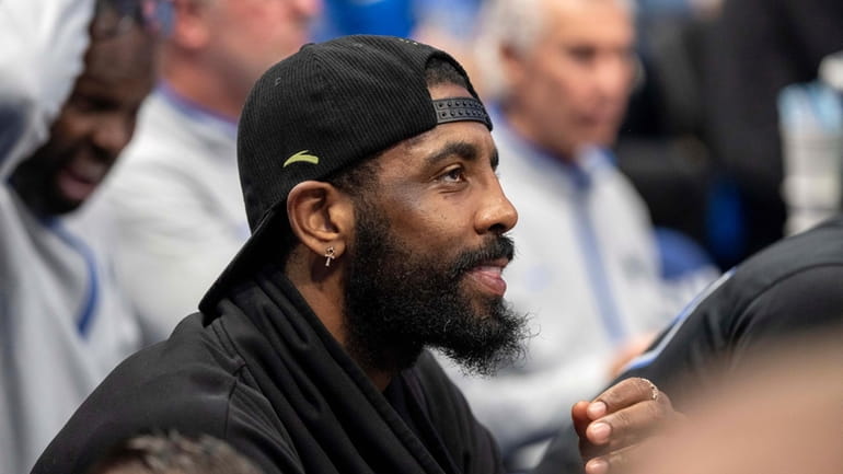 Dallas Mavericks' Kyrie Irving watches from the bench during the...