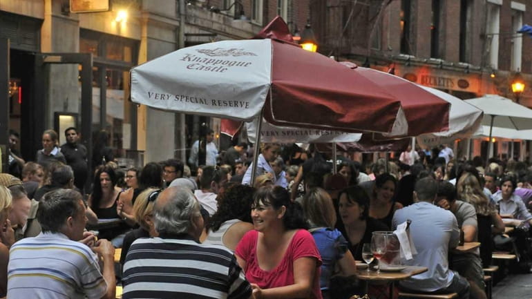 Patrons enjoy food and drinks on Stone Street in Lower...