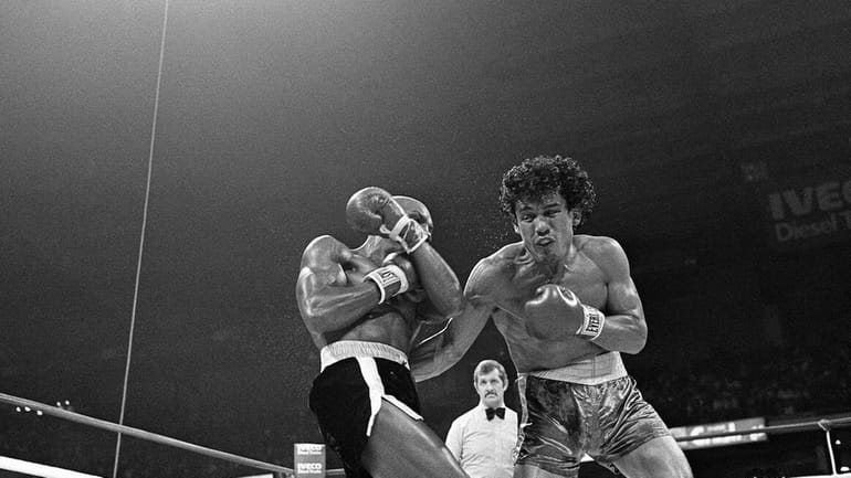 Title contender Mustafa Hamsho, right, recoils from hard left by...