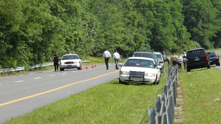 Homicide detectives investigate a wooded area on northbound Nicolls Road...