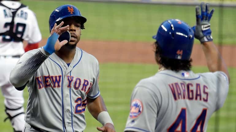 The Mets' Dominic Smith, left, is met by Jason Vargas...