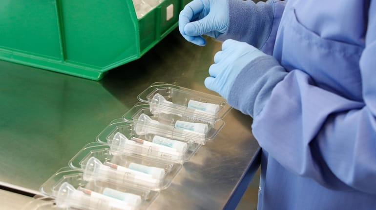 A worker assembles Covid-19 saliva test kits at Spectrum Solutions...