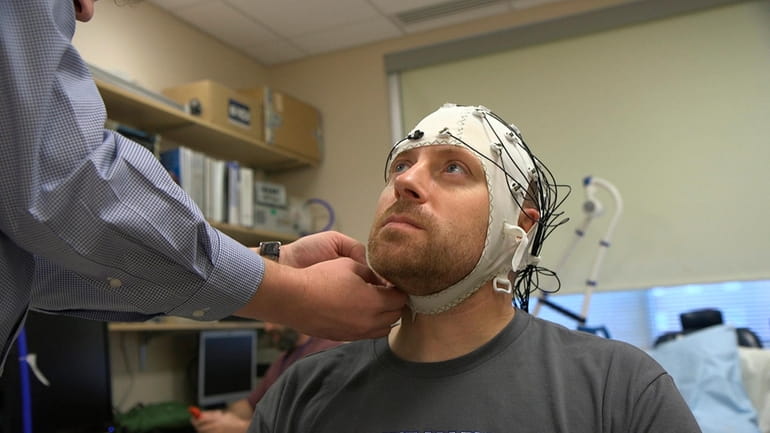 Zach Ault, who has ME/CFS, is fitted with an EEG...