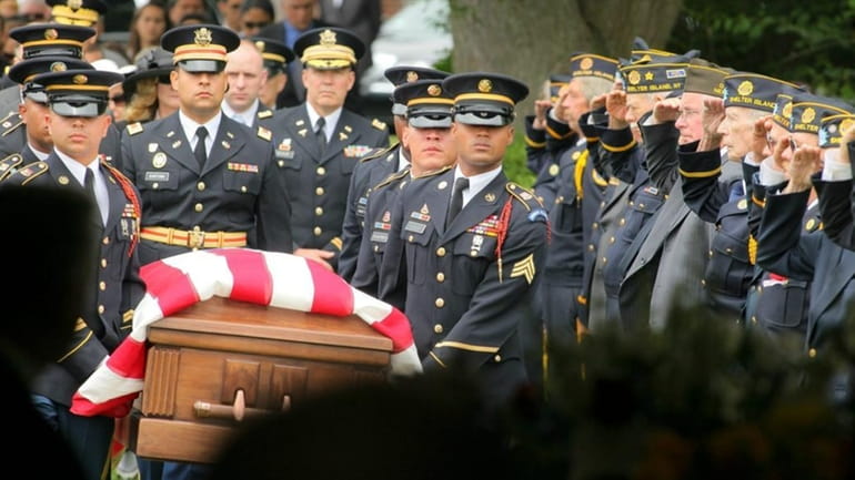 The coffin is carried in at the funeral Friday for...