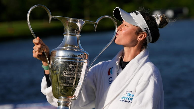 Nelly Korda kisses the trophy while posing for photos after...