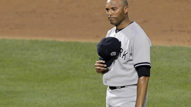 Mariano Rivera of the Yankees takes the mound and tips...