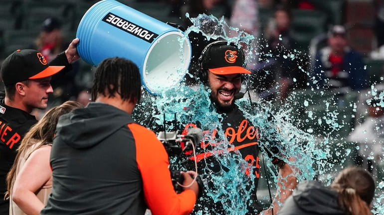 Baltimore Orioles' Anthony Santander is doused by teammate Adam Frazier,...