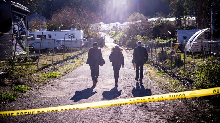 FBI officials walk towards from the crime scene at Mountain...