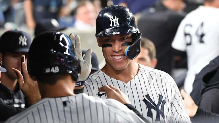 The Yankees' Aaron Judge reacts in the dugout after he...