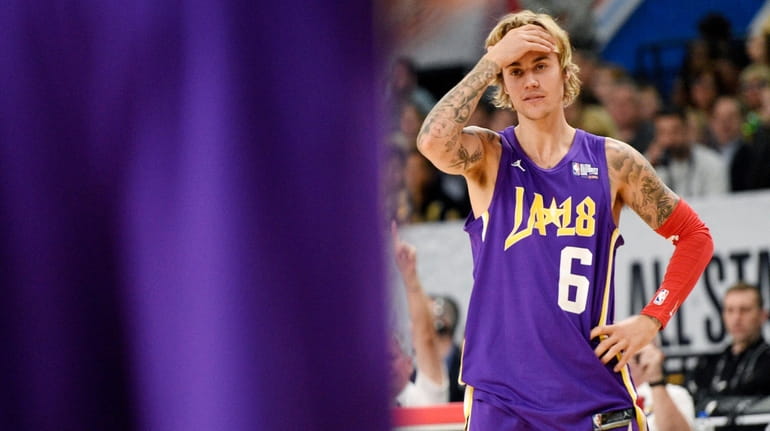  Justin Bieber reacts to a play during the NBA All-Star celebrity...