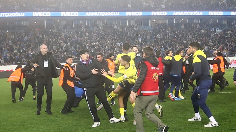 Fenerbahce's players clash with Trabzonspor supporters at the end of...