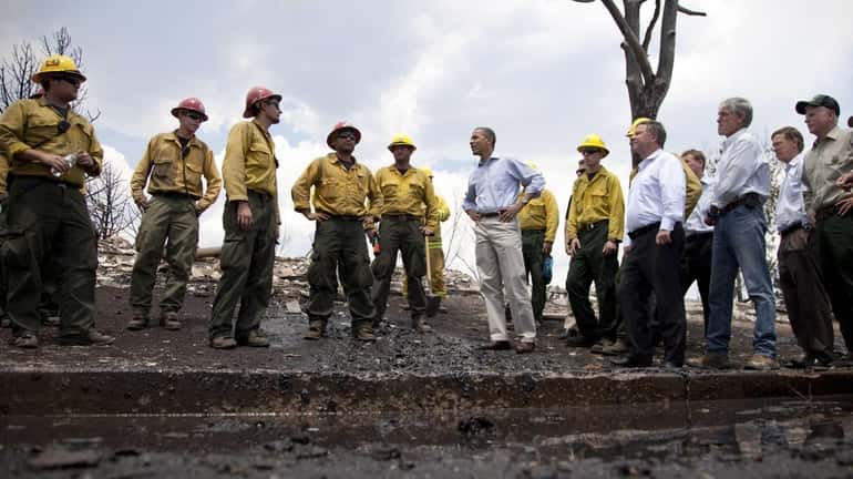 President Barack Obama talks with firefighters as he tours the...