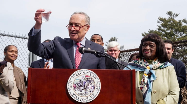 Sen. Chuck Schumer holds a "half-full" cup of water Monday as...