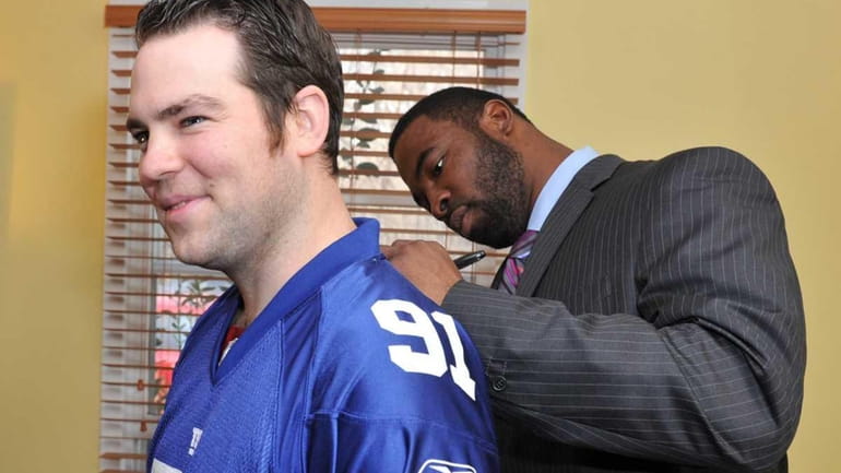 NYPD officer Kevin Brennan gets his Giants jeresey signed in...
