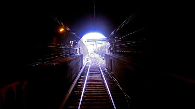 An LIRR train travels east  inside an East River Tunnel.