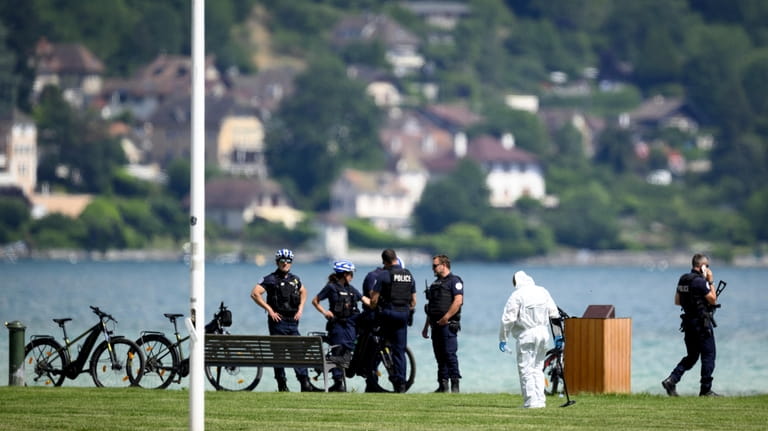 Security forces examine the scene of knife attack in Annecy,...