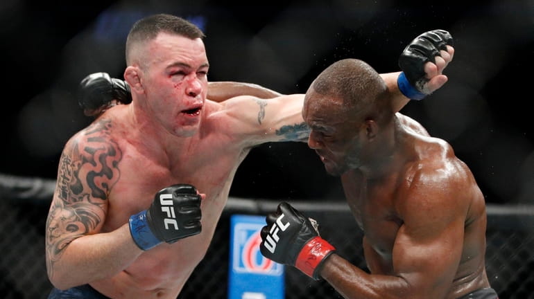 Kamaru Usman, right, fights Colby Covington in a mixed martial...