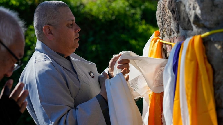 Buddhist faith leaders drape Tibetan scarves on the Birthplace of...