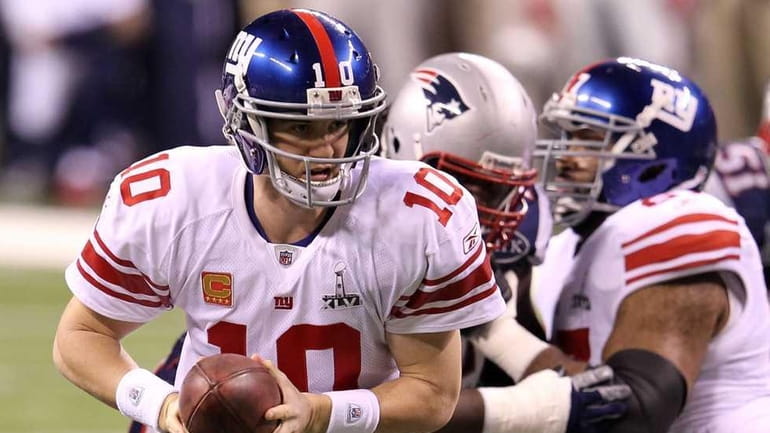 Eli Manning of the New York Giants looks to hand...