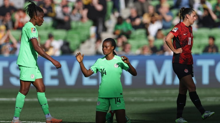 Nigeria's Blessing Demehin and teammate Osinachi Ohale, left, and Canada's...