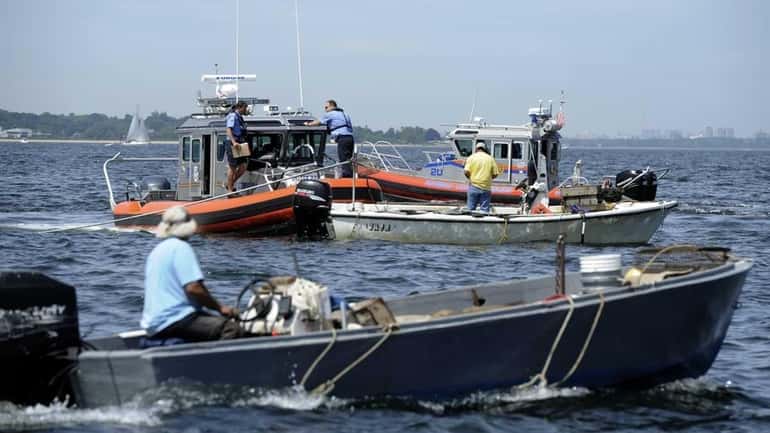 Oyster Bay constable and Nassau police watch clammers on Saturday,...
