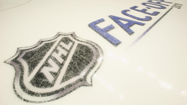 NHL logos are etched into the ice prior to the...