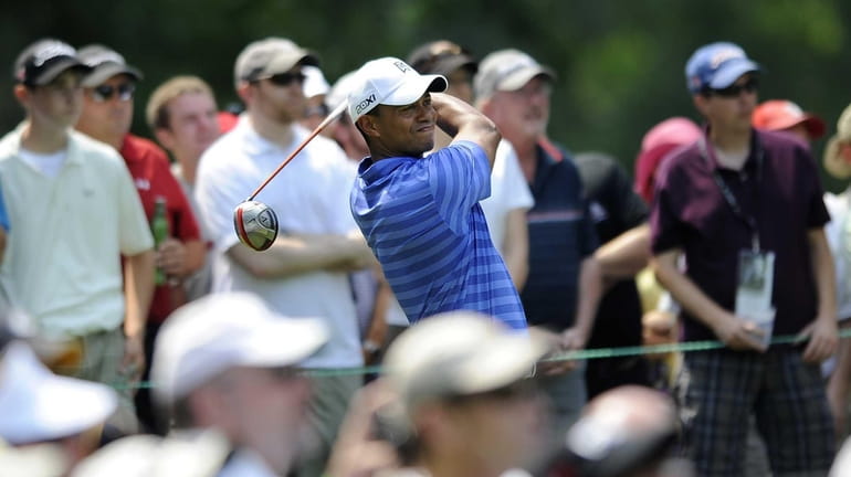 Tiger Woods watches his drive from the fourth tee during...