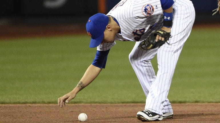 New York Mets shortstop Wilmer Flores reacts after making a...