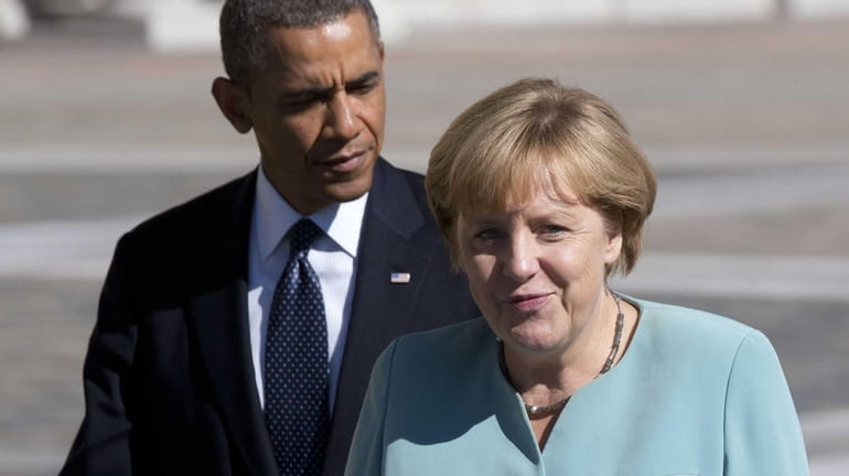 President Barack Obama walks with Germany's Chancellor Angela Merkel toward...