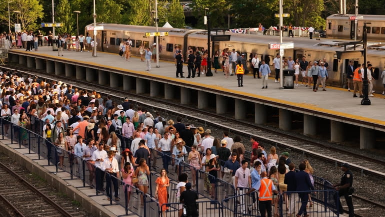 Racegoers board trains at the Belmont Park LIRR station after...