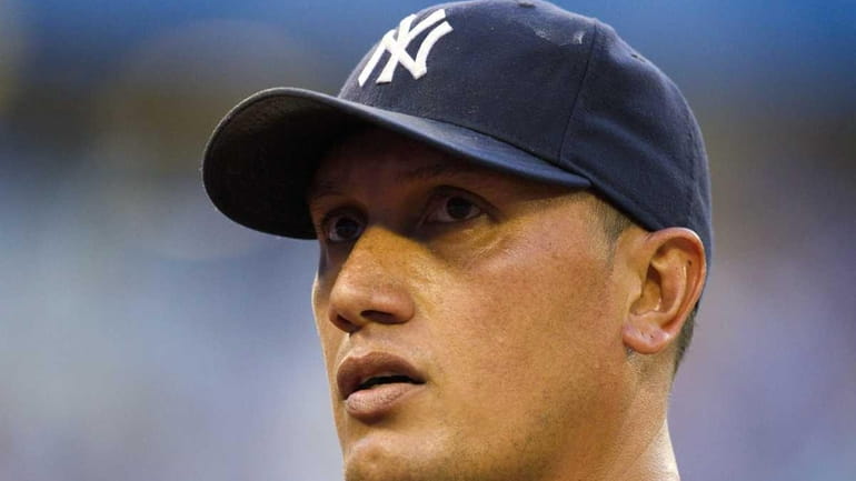 New York Yankees starting pitcher Freddy Garcia walks off the...