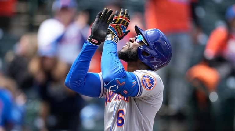 Mets' Starling Marte gestures skyward as he crosses home plate...
