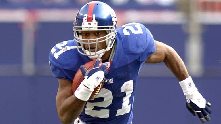 Tiki Barber runs in the first half against the Houston...