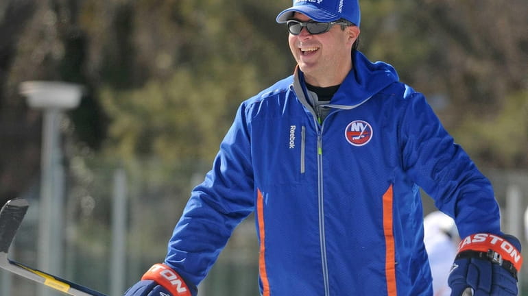 Islanders head coach Jack Capuano laughs during an outdoor practice...