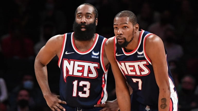Nets guard James Harden and forward Kevin Durant look on...