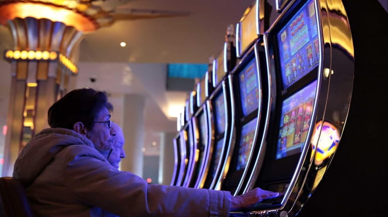 Patrons try their luck on gaming machines at the Empire City...