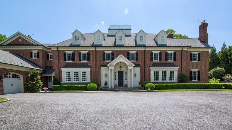 This Georgian-style brick home in Huntington sits next to 900...
