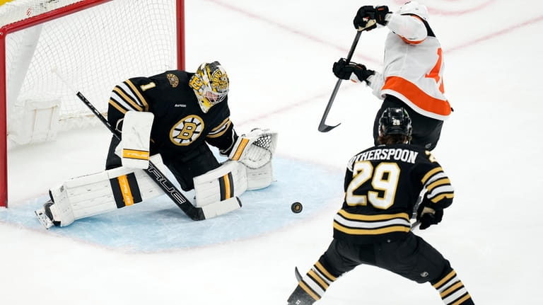 Boston Bruins' Jeremy Swayman blocks a shot by Philadelphia Flyers'...