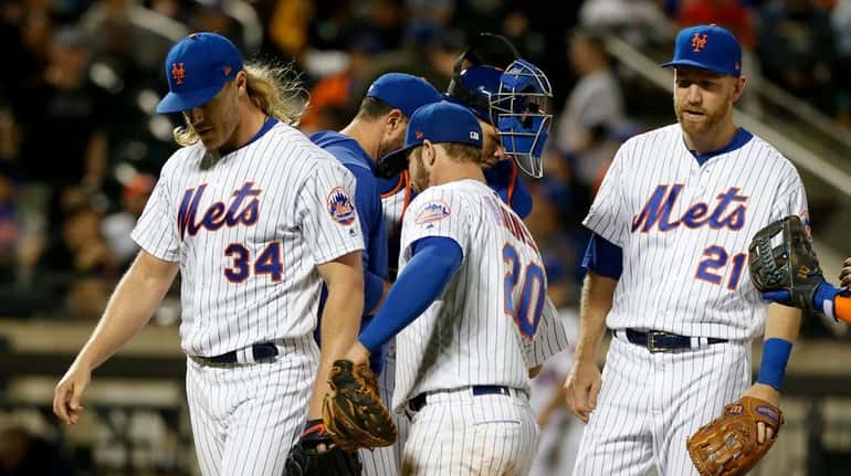 Noah Syndergaard of the Mets walks to the dugout as he...