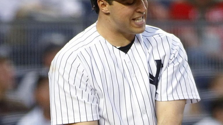 New York Yankees' Mark Teixeira (25) grimaces after fouling a...