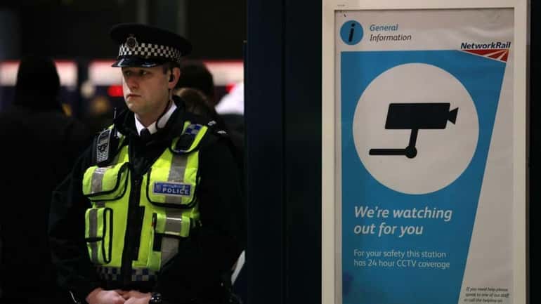 A police officer patrols King's Cross train station in London....