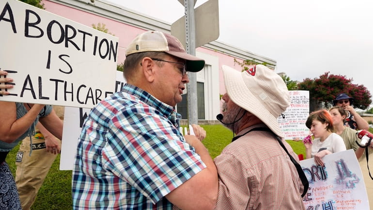 Anti-abortion activist Doug Lane, right, is confronted by abortion rights...