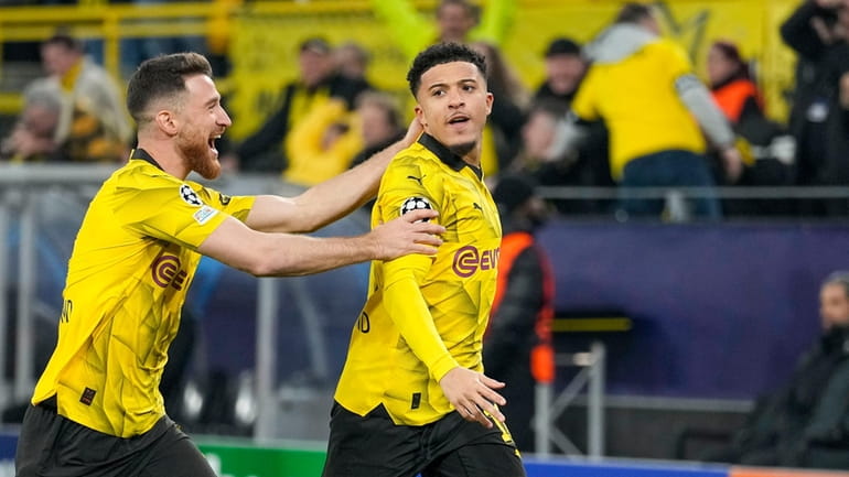 Dortmund's Jadon Sancho, right, celebrates with Dortmund's Salih Ozcan after...