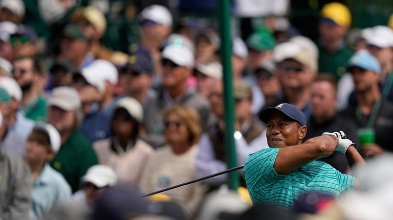 FILE - Tiger Woods tees off on the eighth hole...