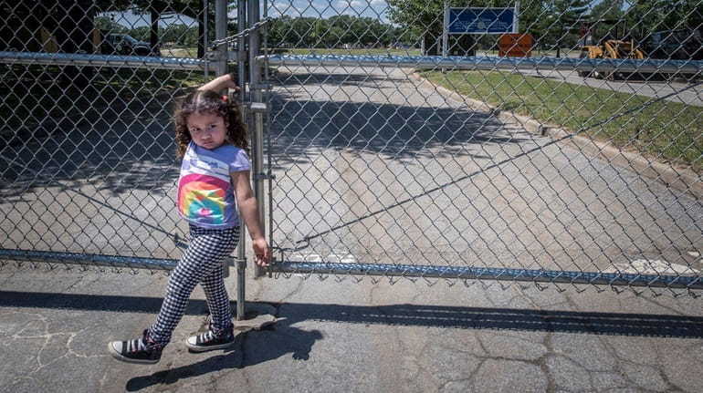 Brentwood resident Miley Chavez, 3, pulls at the locked gate...