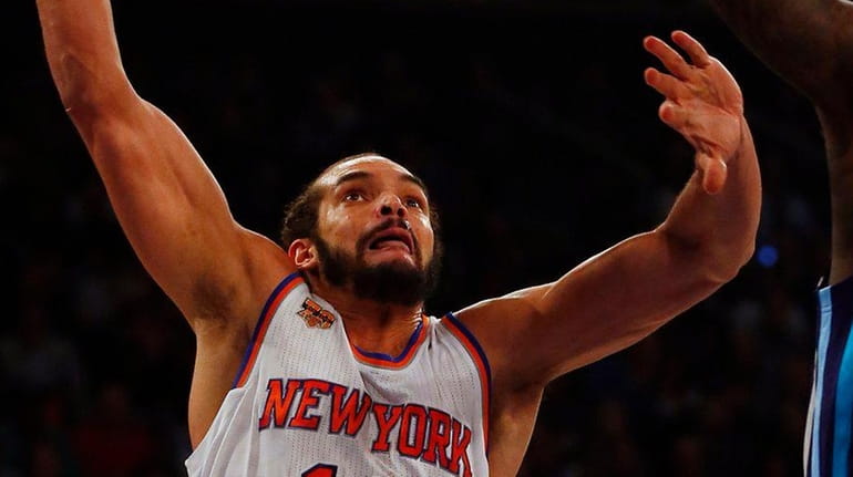 Joakim Noah of the New York Knicks goes to the...