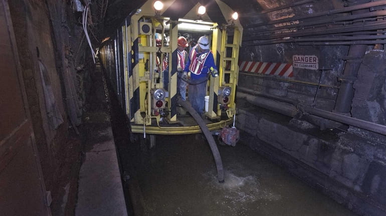 MTA employees using a pump train are working around the...